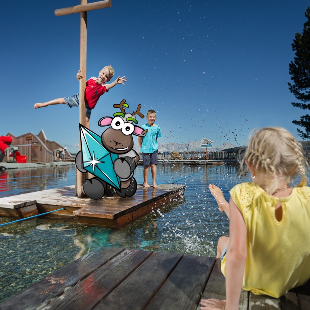 Drei Kinder spielen an einem See, während ein Zeichentrick-Rentier mit einem Drachen die Pauschalangebote im Ötztal genießt.